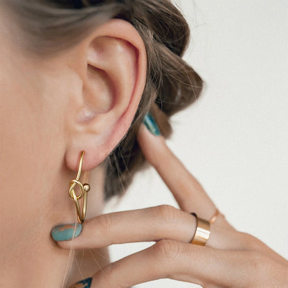 Close-up of Oval Hoop in 14K Gold Geometric Twisted Huggie Hoops Earrings