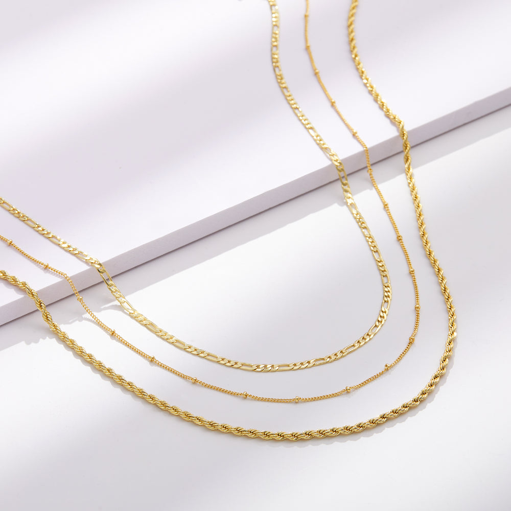 Close-up of 14K Gold Layered Necklaces - Satellite, Figaro, Rope Chain